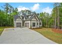 Stylish home with a large concrete driveway and two-car garage, set against a backdrop of mature trees at 3780 Tamiami Trl, Cumming, GA 30041