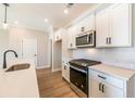 Modern kitchen with white cabinets, stainless steel appliances, and quartz countertops at 135 Bluffington Way, Marietta, GA 30066