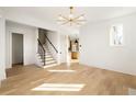 Open living space with hardwood floors, a staircase, and a glimpse into the modern kitchen design at 10931 Serenbe Ln, Chattahoochee Hills, GA 30268