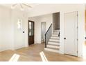 Elegant living room featuring hardwood floors, stairs with iron railing, and a view of the entryway at 10931 Serenbe Ln, Chattahoochee Hills, GA 30268