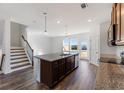 Open-concept kitchen with large island, stainless steel sink, pendant lights, and hardwood floors at 3269 Durston Ct, Dacula, GA 30019