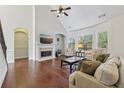 Bright living room features a fireplace, hardwood floors, large windows, and vaulted ceilings at 2420 Bronze Ct, Cumming, GA 30041