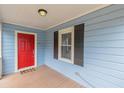 Inviting porch with a bright red door, complementing the home's light blue siding and dark shutters at 1849 W Forrest Ave, East Point, GA 30344