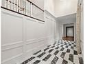 Hallway with high ceilings, elegant marble floors, white paneled walls, and staircase at 3488 Tuxedo Nw Rd, Atlanta, GA 30305