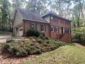 Two-story brick home with attached garage and landscaping at 1461 Fox Forest Sw Ter, Lilburn, GA 30047