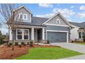 Attractive gray home with a two-car garage and well-kept landscaping enhances its charming curb appeal at 231 Strawberry Ln, Woodstock, GA 30189