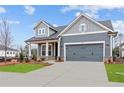 Stylish gray home featuring a well-maintained lawn, complemented by a two-car garage and inviting curb appeal at 231 Strawberry Ln, Woodstock, GA 30189