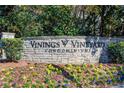 Vinings Vineyard Condominiums stone entrance sign surrounded by colorful flowers and greenery at 4100 Paces Se Walk # 1306, Atlanta, GA 30339