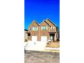 A two-story townhome with brown siding, a white garage door, and green shutters at 3102-A Brownstone Se Ln, Atlanta, GA 30354