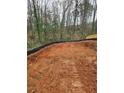 Graded construction lot ready for building, showing soil and surrounding trees at 1664 Crestridge Se Dr, Marietta, GA 30067