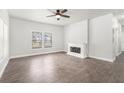 Bright living room features a decorative fireplace, ceiling fan, and wood-look flooring at 1220 Hightower Nw Rd, Atlanta, GA 30318