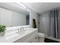 Bright bathroom features a large vanity mirror, walk-in shower with sleek gray curtain at 2870 Pharr Court South Nw # 2602, Atlanta, GA 30305