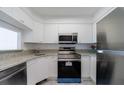 Efficient kitchen with stainless steel appliances, white cabinets, and granite countertops at 2870 Pharr Court South Nw # 2602, Atlanta, GA 30305