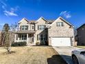 Two-story brick home with a large front yard and attached garage, car parked in driveway at 7860 Bristol Valley Dr, Cumming, GA 30028