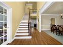 Inviting foyer showcasing hardwood floors, stairs with iron spindles, and access to various rooms at 3423 Mulberry Lane Ct, Dacula, GA 30019