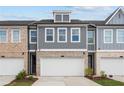 Townhouse exterior with gray siding, brick accents, and a two-car garage at 1068 Rose Dr, Marietta, GA 30060