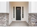 Elegant front entry with stone pillars and a black front door at 4790 Briscoe Dr, Cumming, GA 30028