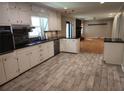Updated kitchen with white cabinets, black countertops, tile floors, and stainless steel dishwasher at 2479 Landeau Cir, Tucker, GA 30084