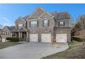 Well-manicured two-story brick home featuring a spacious three-car garage at 7691 Brazos Trl, Fairburn, GA 30213