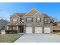 Beautiful two-story brick home with a three-car garage and lush front yard at 7691 Brazos Trl, Fairburn, GA 30213