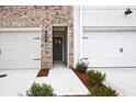 Attractive townhome exterior with a two-car garage and landscaped front yard at 697 Sunstone Ln, Lawrenceville, GA 30043