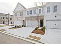 Street view of inviting townhomes with two car garages and sidewalk access at 697 Sunstone Ln, Lawrenceville, GA 30043