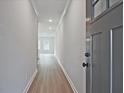 A well-lit hallway with wood-look flooring and a neutral color palette at 697 Sunstone Ln, Lawrenceville, GA 30043