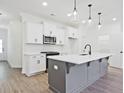 Modern kitchen with white cabinets, gray island, and stainless steel appliances at 717 Trevett Way, Marietta, GA 30062