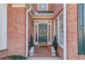 Green front door flanked by windows and stone lion statues at 905 Fairview Club Cir, Dacula, GA 30019