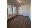 A bright bedroom featuring wood-look flooring, a window with blinds, and neutral paint at 2280 Highridge Point Dr, Lithia Springs, GA 30122