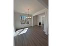 Elegant dining room with modern chandelier, wainscoting, and fireplace, with wood-look flooring at 2280 Highridge Point Dr, Lithia Springs, GA 30122