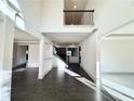 Bright open foyer featuring dark hardwood floors, high ceilings, and a staircase with black metal railings at 990 Botanica Way, Fairburn, GA 30213