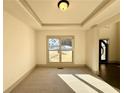 Cozy living room with plush carpet, recessed lighting, and a large window offering a view of the outdoors at 990 Botanica Way, Fairburn, GA 30213