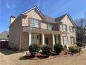 Attractive brick home featuring a covered front porch and manicured shrubbery at 1251 Marlton Chase Dr, Lawrenceville, GA 30044