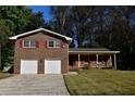 Traditional brick home with a two-car garage, complemented by red shutters and a well-maintained lawn at 2071 Carthage Rd, Tucker, GA 30084