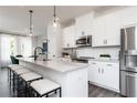 Modern kitchen with stainless steel appliances, white cabinets, large island with stool seating, and pendant lighting at 363 Skylar Se Way, Atlanta, GA 30315