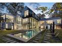 Stunning modern home with a pool, lounge chairs, and large windows offering picturesque views at 2716 Ridgewood Nw Rd, Atlanta, GA 30327