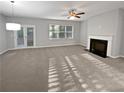 Bright living room with fireplace, ceiling fan, and french doors leading to backyard at 3279 Wild Basil Ln, Buford, GA 30519