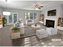Bright living room with fireplace, ceiling fan, and french doors leading to backyard at 3279 Wild Basil Ln, Buford, GA 30519