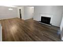 Open-concept living area with a fireplace and dining space, featuring modern wood-look flooring at 504 Vicksburg Pl, Atlanta, GA 30350