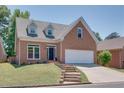 Two-story house featuring brick facade, white garage door, and stone steps at 4083 Brookside Manor Dr, Tucker, GA 30084