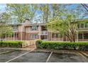 Condo building with a wooden walkway and parking lot at 261 Quail Run, Roswell, GA 30076