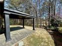 View of covered patio, landscaping and trees in the backyard at 1873 Jameson Cir, Lawrenceville, GA 30043