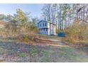 House's back view, showing a shed and wooded area at 448 Strickland Ct, Lawrenceville, GA 30046