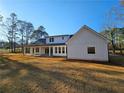 Striking two story home with white siding, lots of windows, and a covered patio at 1632 Oleander Sw Dr, Lilburn, GA 30047