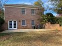 A spacious backyard features a brick patio, lush lawn, mature trees, and air conditioning units at 229 Smithstone Path, Fayetteville, GA 30214