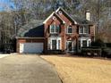 Charming two-story brick home with a well-manicured lawn, attached garage, and inviting curb appeal at 1025 Charleston Trce, Roswell, GA 30075