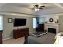 Main bedroom with a king-size bed, fireplace, and built-in media console at 1025 Charleston Trce, Roswell, GA 30075