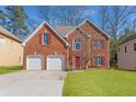 Charming two-story brick home featuring a well-manicured lawn and a two-car garage at 4311 Clairesbrook Ln, Acworth, GA 30101