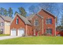 Charming two-story brick home featuring a well-manicured lawn and a two-car garage at 4311 Clairesbrook Ln, Acworth, GA 30101